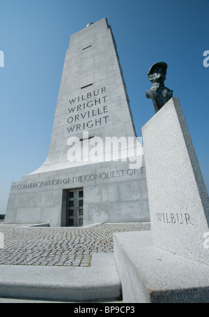 Statut de Wilbur Wright avec monument situé en arrière-plan. Banque D'Images