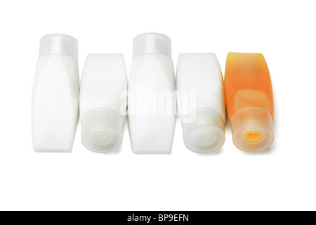 Les tube de shampooing orange parmi des contenants de gel douche sur fond blanc Banque D'Images