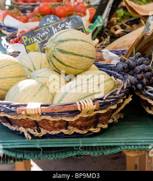 Melons et raisins dans un panier sur un étal du marché en France, prix en Euros Banque D'Images