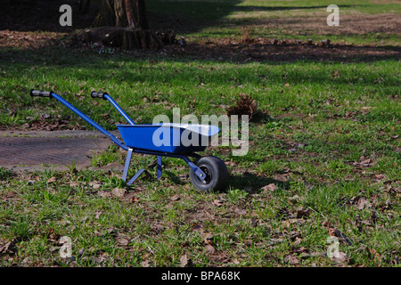 Brouette en fer bleu dans l'herbe Banque D'Images