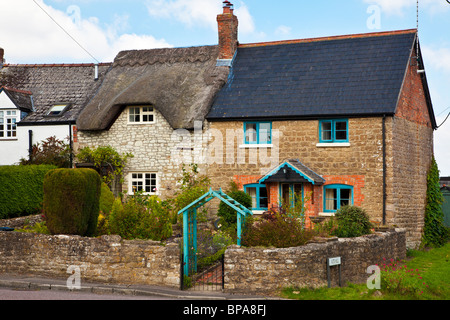 Deux cottages en pierre typiquement anglais, avec un sol carrelé et d'un toit en chaume. Banque D'Images