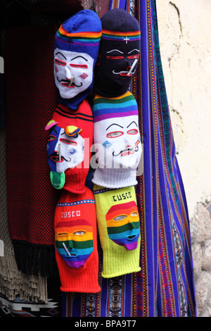 Masques de laine typiques (appelés waqullu ou waq'ollo) utilisés par les danseurs de Kapac Qolla pour la vente dans l'embrasure de porte d'un magasin d'artisanat, Cusco, Pérou Banque D'Images