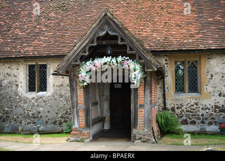 Pyrford l'église Saint-Nicolas. Surrey en Angleterre. Porte de l'église décorée de fleurs pour l'Angleterre. Banque D'Images