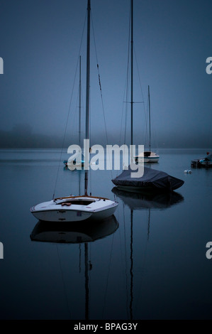 Voiliers sur le brouillard enveloppé Lake Harriet à l'aube. Banque D'Images