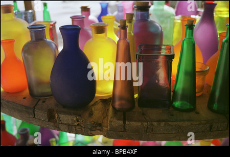 Close-up de couleurs vives, translucide, bouteilles avec bouchons affichée sur table en bois vieilli. Banque D'Images