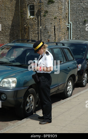 Le trafic des femmes directeur de l'écriture d'un billet de stationnement, Tenby, Pays de Galles, Royaume-Uni Banque D'Images