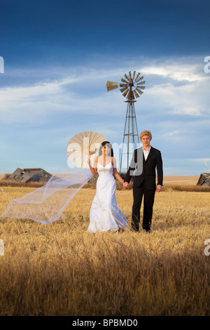 Three Hills, Alberta, Canada ; une bride and groom posing in a farm field Banque D'Images