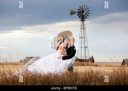 Three Hills, Alberta, Canada ; une femme et un homme dans une embrassade dans un champ agricole Banque D'Images