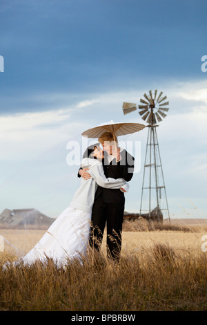 Three Hills, Alberta, Canada ; une femme et un homme dans une embrassade dans un champ agricole Banque D'Images