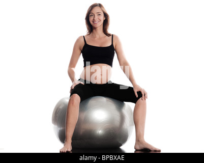 Pregnant caucasian woman sitting on fitness ball studio isolé sur fond blanc Banque D'Images