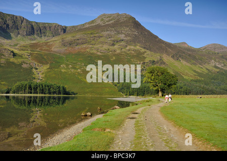 Un couple bénéficiant d'une promenade le long de la rive de la lande dans le Lake District Banque D'Images