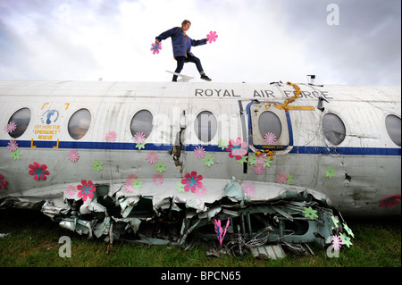 Un artiste décore un vieil avion RAF avec fleurs dans la région de la ville de Corbeille au festival de Glastonbury Pilton site UK Banque D'Images