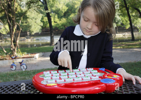 Petite fille jouant avec une éducation jouets électroniques Banque D'Images