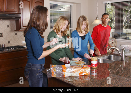 Les adolescents faisant le déjeuner, sandwichs au beurre d'arachide et confiture Banque D'Images