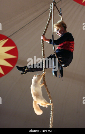 Chat de cirque de grimper une corde à une femme dans les airs. Banque D'Images