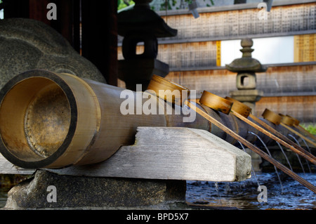 Un bassin de purification avec louches devant un sanctuaire Shinto japonais Banque D'Images