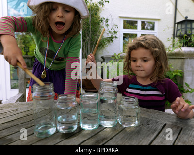 Pour faire de la musique à l'aide de pots de verre plein d'eau et de les frapper avec des cuillères en bois Banque D'Images