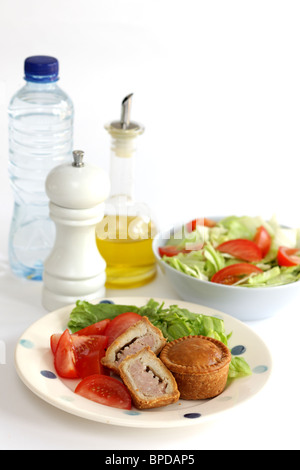 Sarriette fraîche Pork pie avec un mélange de salade du jardin d'été en bonne santé avec aucun peuple contre un fond blanc Banque D'Images