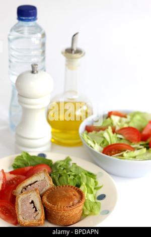 Sarriette fraîche Pork pie avec un mélange de salade du jardin d'été en bonne santé avec aucun peuple contre un fond blanc Banque D'Images