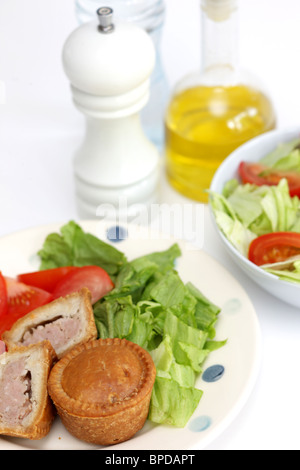 Sarriette fraîche Pork pie avec un mélange de salade du jardin d'été en bonne santé avec aucun peuple contre un fond blanc Banque D'Images