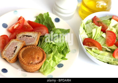 Sarriette fraîche Pork pie avec un mélange de salade du jardin d'été en bonne santé avec aucun peuple contre un fond blanc Banque D'Images