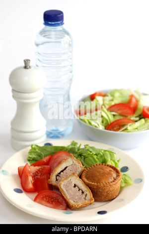 Sarriette fraîche Pork pie avec un mélange de salade du jardin d'été en bonne santé avec aucun peuple contre un fond blanc Banque D'Images