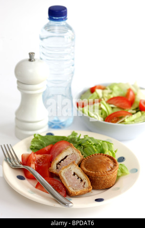 Sarriette fraîche Pork pie avec un mélange de salade du jardin d'été en bonne santé avec aucun peuple contre un fond blanc Banque D'Images