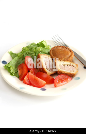 Sarriette fraîche Pork pie avec un mélange de salade du jardin d'été en bonne santé avec aucun peuple contre un fond blanc Banque D'Images