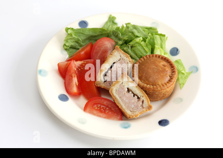 Sarriette fraîche Pork pie avec un mélange de salade du jardin d'été en bonne santé avec aucun peuple contre un fond blanc Banque D'Images