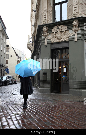 Une dame avec un parapluie à pied d'un immeuble de style Art Nouveau dans le centre historique de Riga. Lativa Banque D'Images