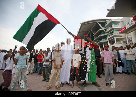 Un homme en agitant le drapeau national des Émirats Arabes Unis, Dubai Banque D'Images