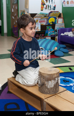 Classe préscolaire préscolaire 4 ans Garçon jouant un petit tambour pendant le cours Banque D'Images