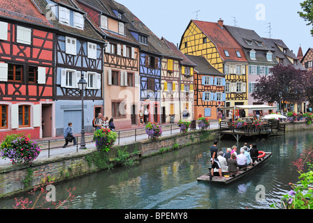 Les touristes en voyage touristique en bateau le long des maisons à colombage colorées à la Petite Venise / La Petite Venise, Colmar, France Banque D'Images