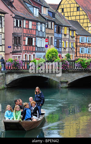 Les touristes en voyage touristique en bateau le long des maisons à colombage colorées à la Petite Venise / La Petite Venise, Colmar, France Banque D'Images