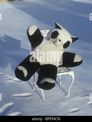 Ours Panda assis sur une chaise dans la neige Banque D'Images