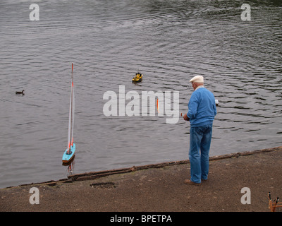 Vieil homme jouant avec un yacht, Seapool. Falmouth, Cornwall, UK Banque D'Images