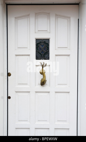 Porte avant en bois blanc avec poisson dragon heurtoir sur Fishpool Stret, St Albans, Royaume-Uni. Banque D'Images