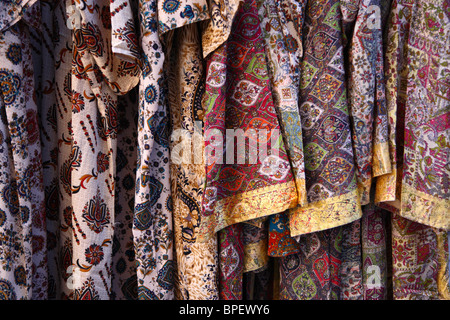 Une ligne de vêtements colorés suspendus à un rack dans le marché de Boukhara en Ouzbékistan. Banque D'Images