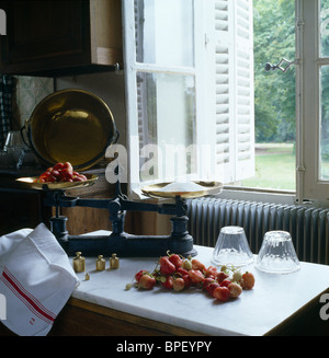 Balances anciennes des marbres et recouvert de marbre sur le tableau ci-dessous fenêtre de cuisine aux volets blancs Banque D'Images