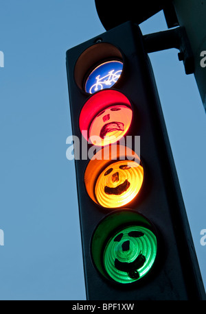 Visages sur les feux de circulation à vélo à la tombée de la nuit à Berlin Allemagne Banque D'Images