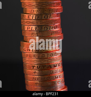 Piles de pièces de monnaie en livres sterling britanniques sur un fond noir Banque D'Images