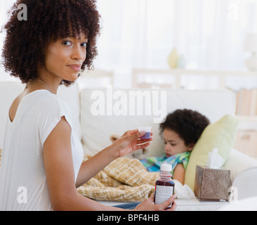 Mère de donner du sirop contre la toux pour fille malade Banque D'Images