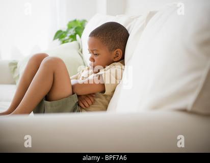 African American boy malheureux sur canapé Banque D'Images