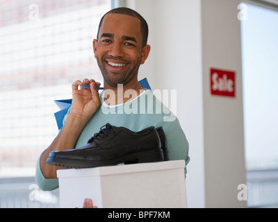 Mixed Race shopper holding shoe et fort Banque D'Images