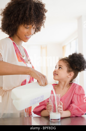 Verser dans un verre de lait de la mère pour fille Banque D'Images