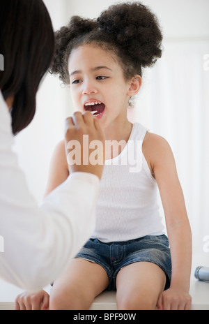 Pédiatre avec abaisse-langue examining patient Banque D'Images