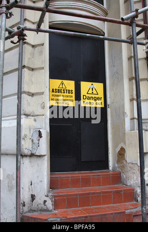 Panneaux d'avertissement d'amiante sur un bâtiment abandonné dans une ville du Royaume-Uni. Banque D'Images