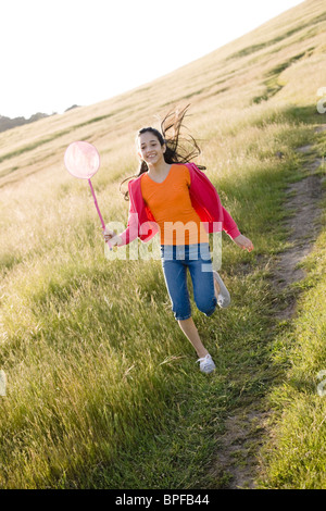 Hispanic girl running in field avec net Banque D'Images