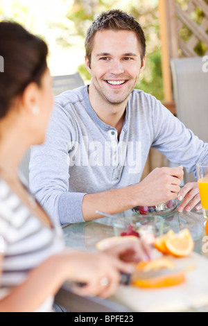 Couple eating breakfast on patio Banque D'Images