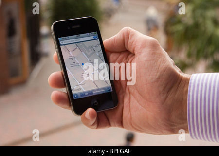 L'iPhone 4 dans la main d'un homme montrant l'application Google maps, soulignant son emplacement à Nyköping, Suède. Banque D'Images